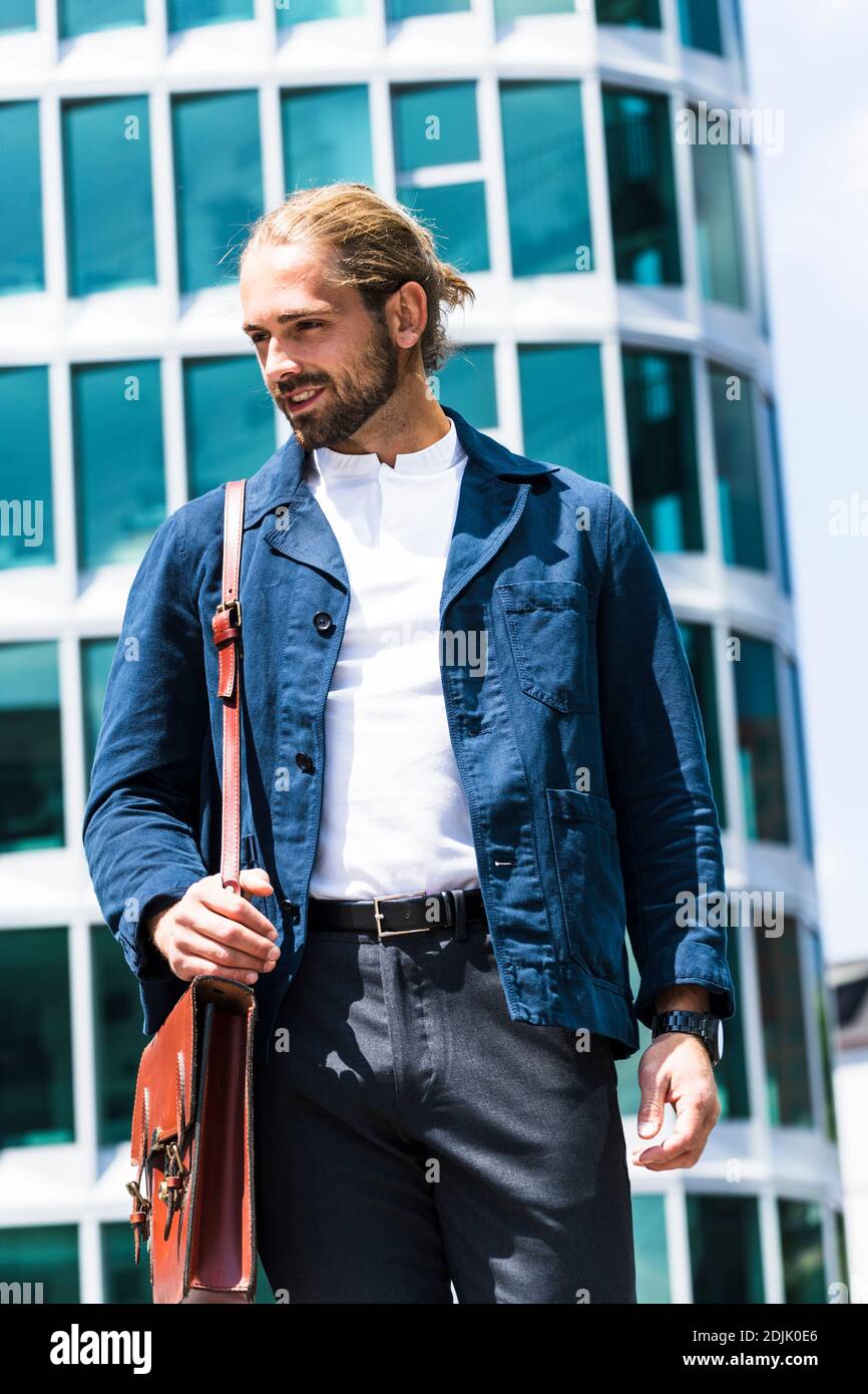 Junger Mann mit Mann bun aus und um in der Stadt Stockfoto