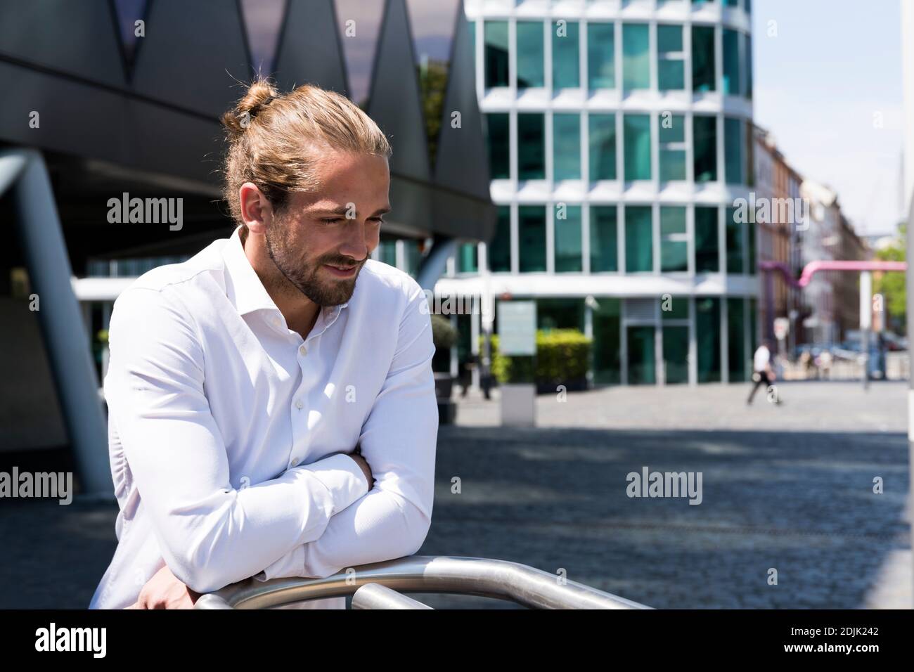 Junger Mann mit Mann bun aus und um in der Stadt Stockfoto