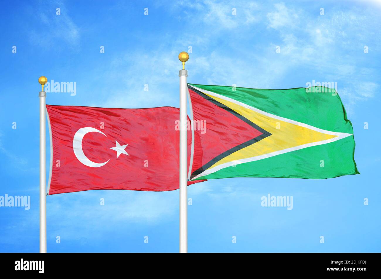 Türkei und Guyana zwei Flaggen auf Fahnenmasten und blau bewölkt Himmel Stockfoto