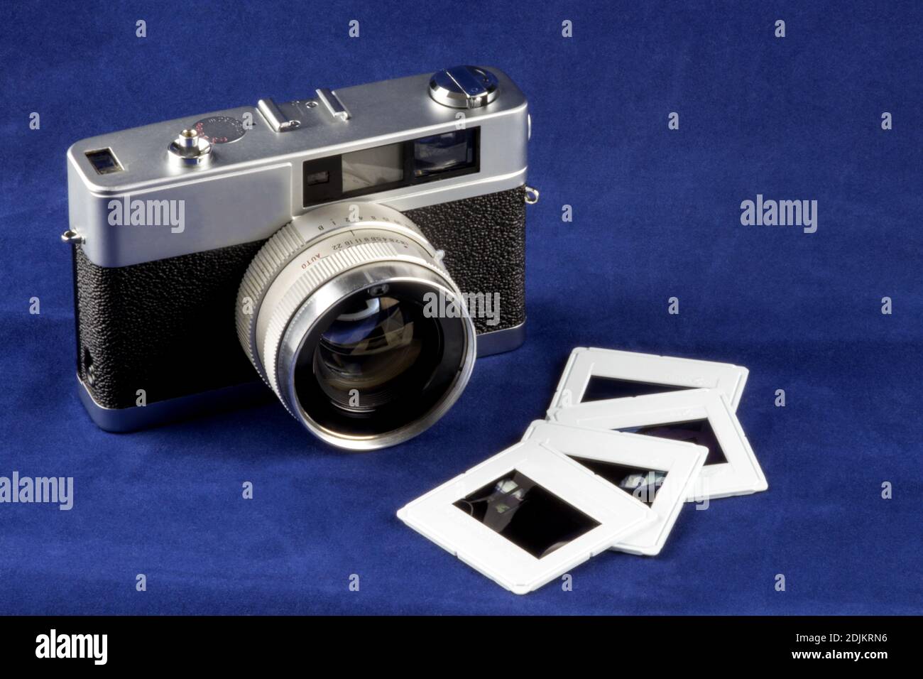 Alte Filmkamera mit Diafilm isoliert auf einem blauen Tischplatte Stockfoto