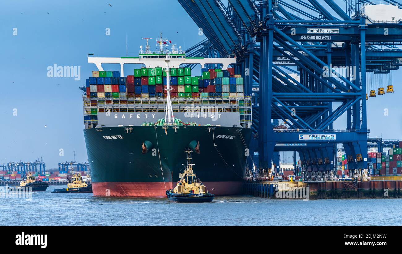 Das jemals begnadete Containerschiff wird von drei Schleppern im Felixstowe Port, dem größten Containerhafen Großbritanniens, in Position gebracht. Stockfoto