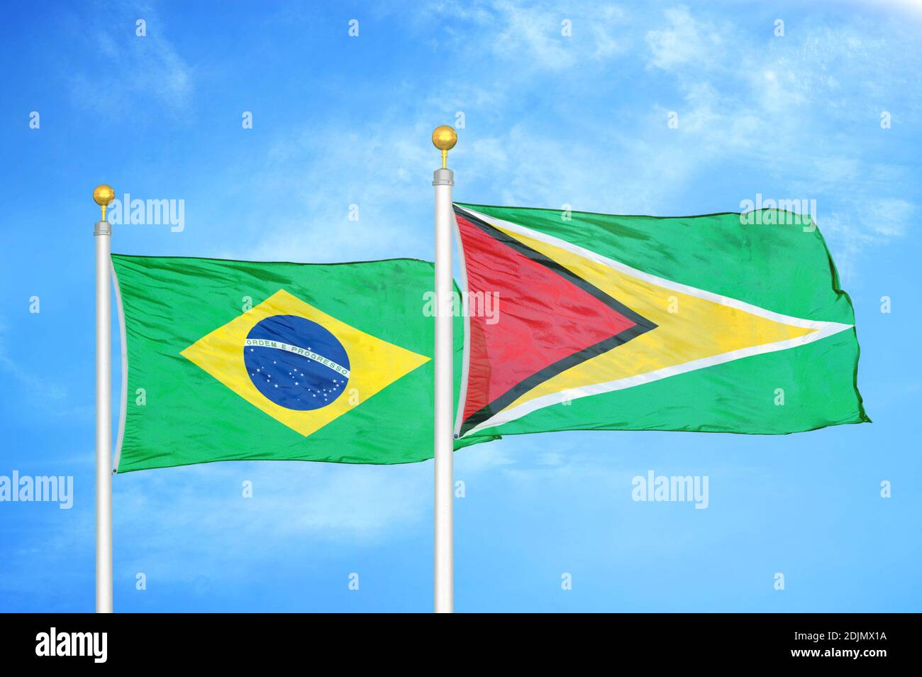 Brasilien und Guyana zwei Flaggen auf Fahnenmasten und blau bewölkt Himmel Stockfoto