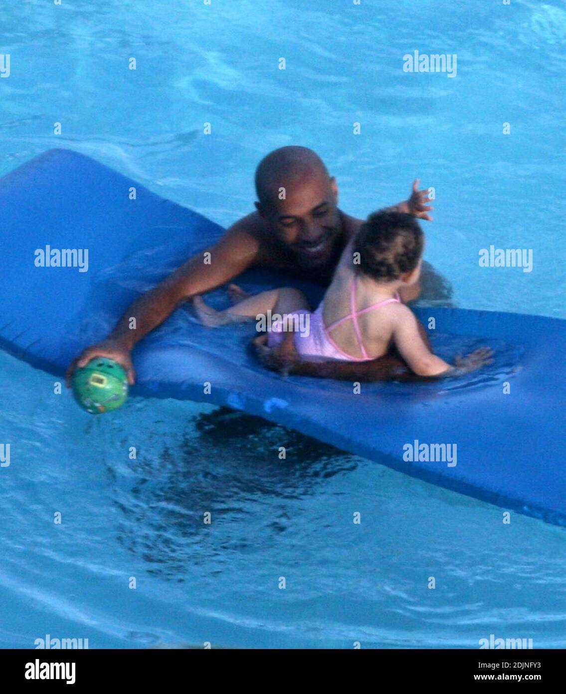 Exklusiv!! Frankreich und Arsenal Fußball-Ass Thierry Henry gibt Tochter Tee einige Lektionen in Schwimmen und Ballkontrolle. Frau Nicole Merry, die den Morgen mit Sonnenbaden verbrachte, schaute auf und wie jede stolze Mutter mit ihrer Digitalkamera wegschnappte. Am Morgen sonbte Nicole jeden Tag eineinhalb Stunden lang solo, während sie auf ihrem Mobiltelefon plauderte, non-stop, Miami Beach, FL, 7/25/06 Stockfoto