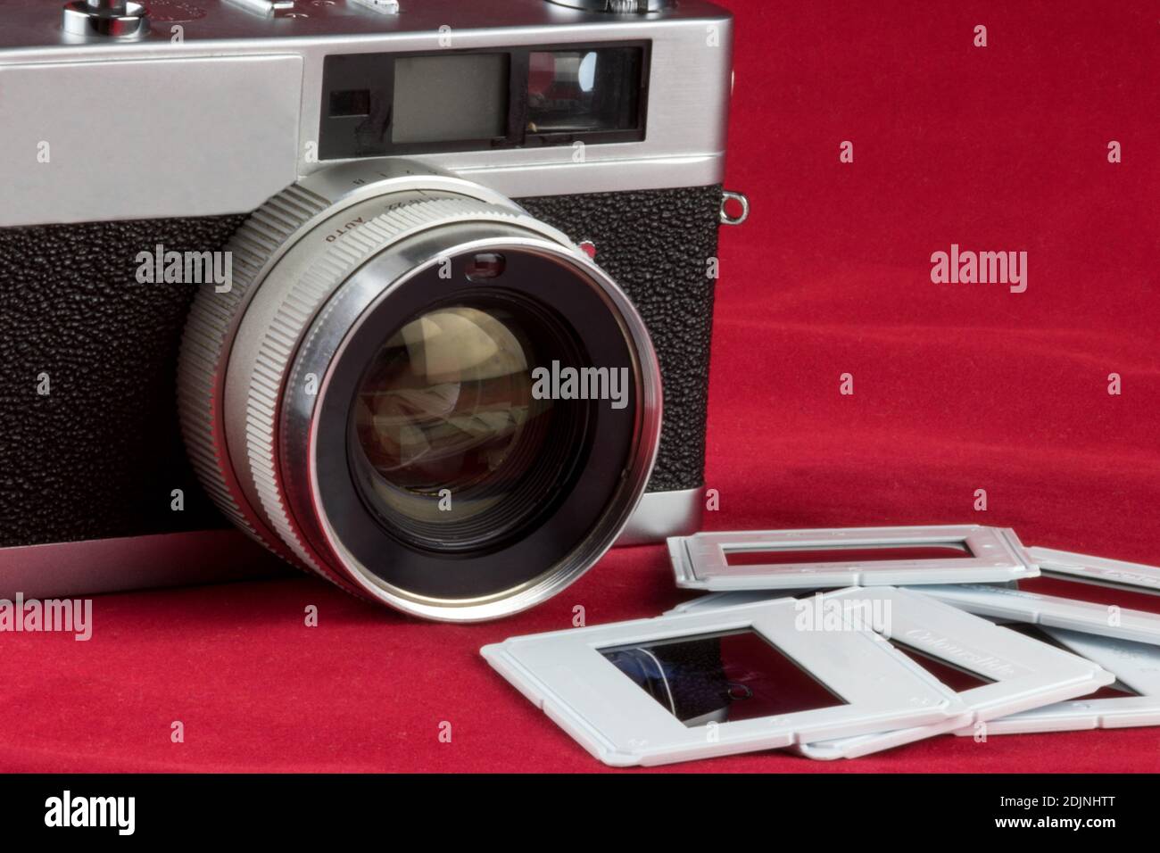 Alte Filmkamera mit Diafilm isoliert auf einem roten Tischplatte Stockfoto
