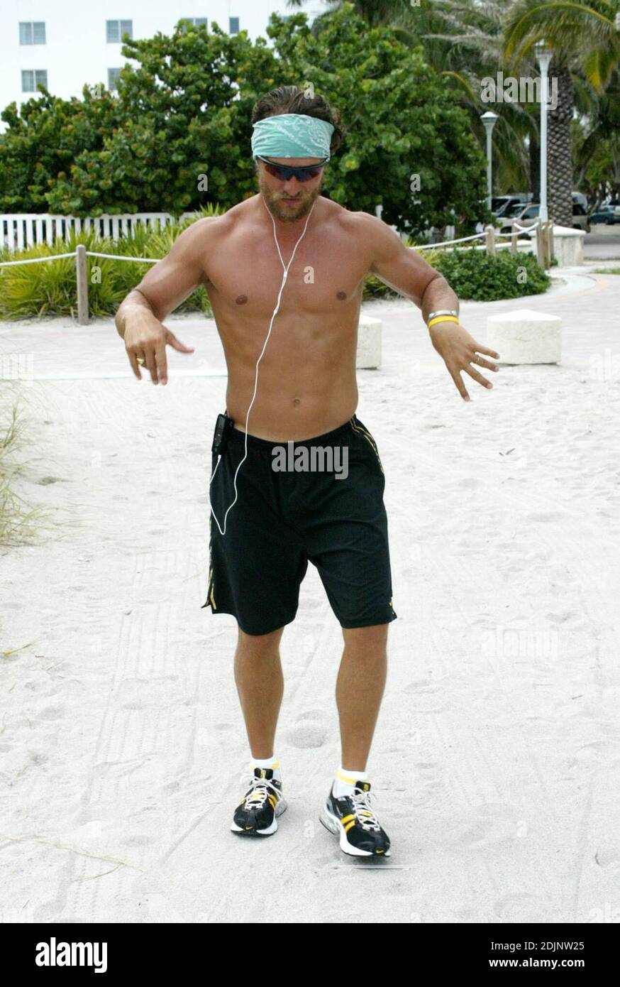 Matthew McConaughey erwärmt sich für sein Beach Workout, indem er sich auf einige Melodien auf seinem iPod. Nach dem Joggen mit pal Lance Armstrong, ging er die Promenade zu den nächsten Erfrischungen, gefolgt von lokalen Fotografen, die kämpfen, um Schritt zu halten, Miami Beach, FL, 8/23/06 Stockfoto