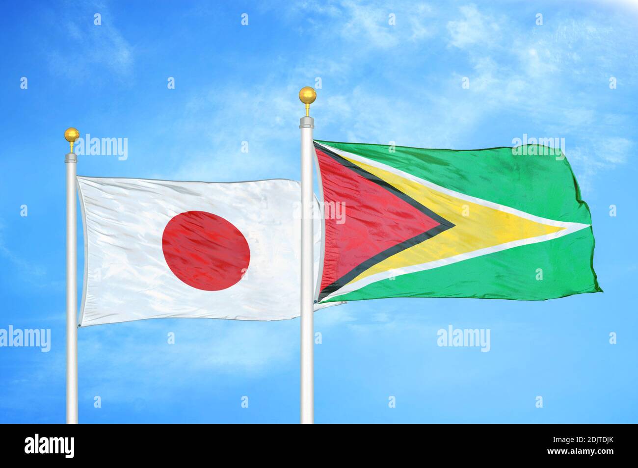 Japan und Guyana zwei Flaggen auf Fahnenmasten und blau bewölkt Himmel Stockfoto