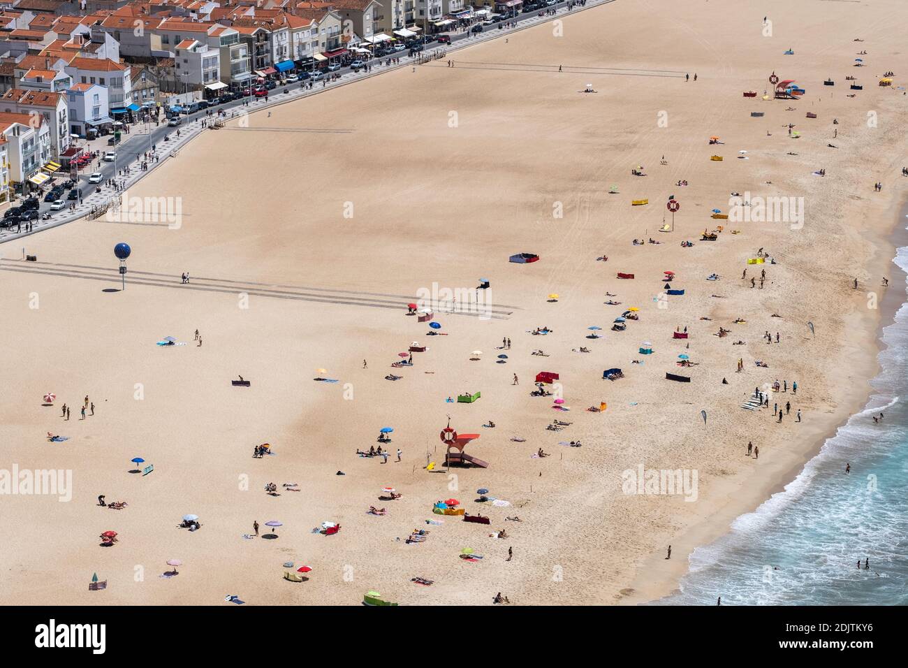 Hohe Sicht auf viele Menschen am Sand des Strandes in der Nähe der Stadt von oben gesehen, während eines sonnigen Sommertages Stockfoto