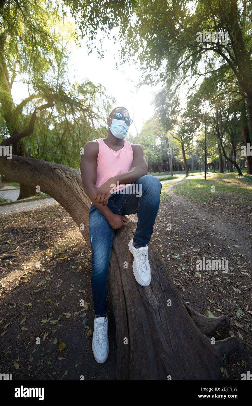 Ein junger schwarzer Mann mit einer Maske in der covid-19 Pandemie-Saison. Stockfoto