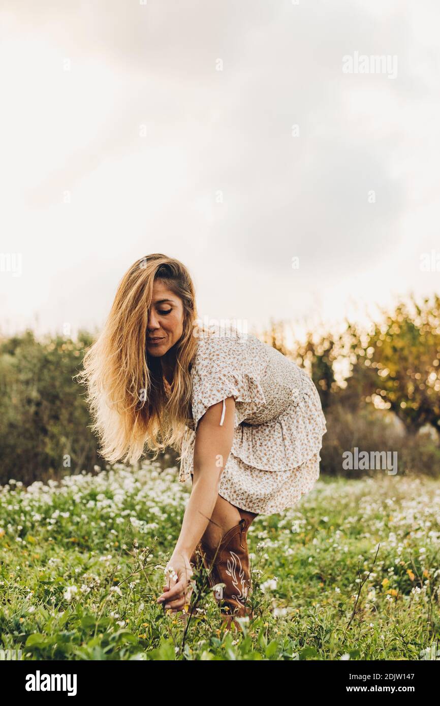 Frau In Der Natur Beugte Sich Um Einige Blumen Mit Zu Fangen Ihre Hände Stockfoto