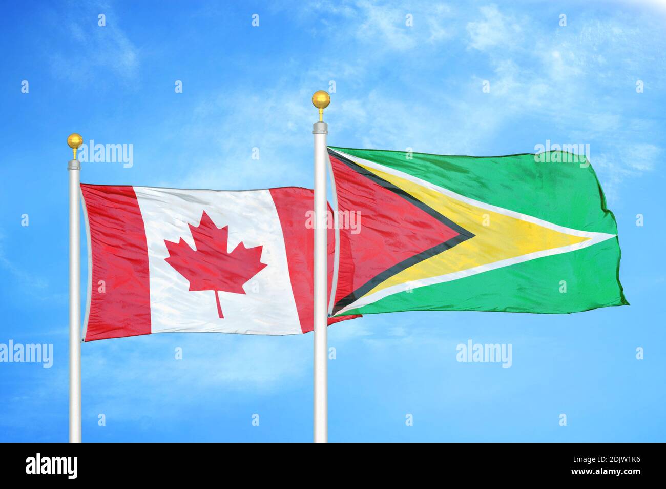 Kanada und Guyana zwei Flaggen auf Fahnenmasten und blau bewölkt Himmel Stockfoto
