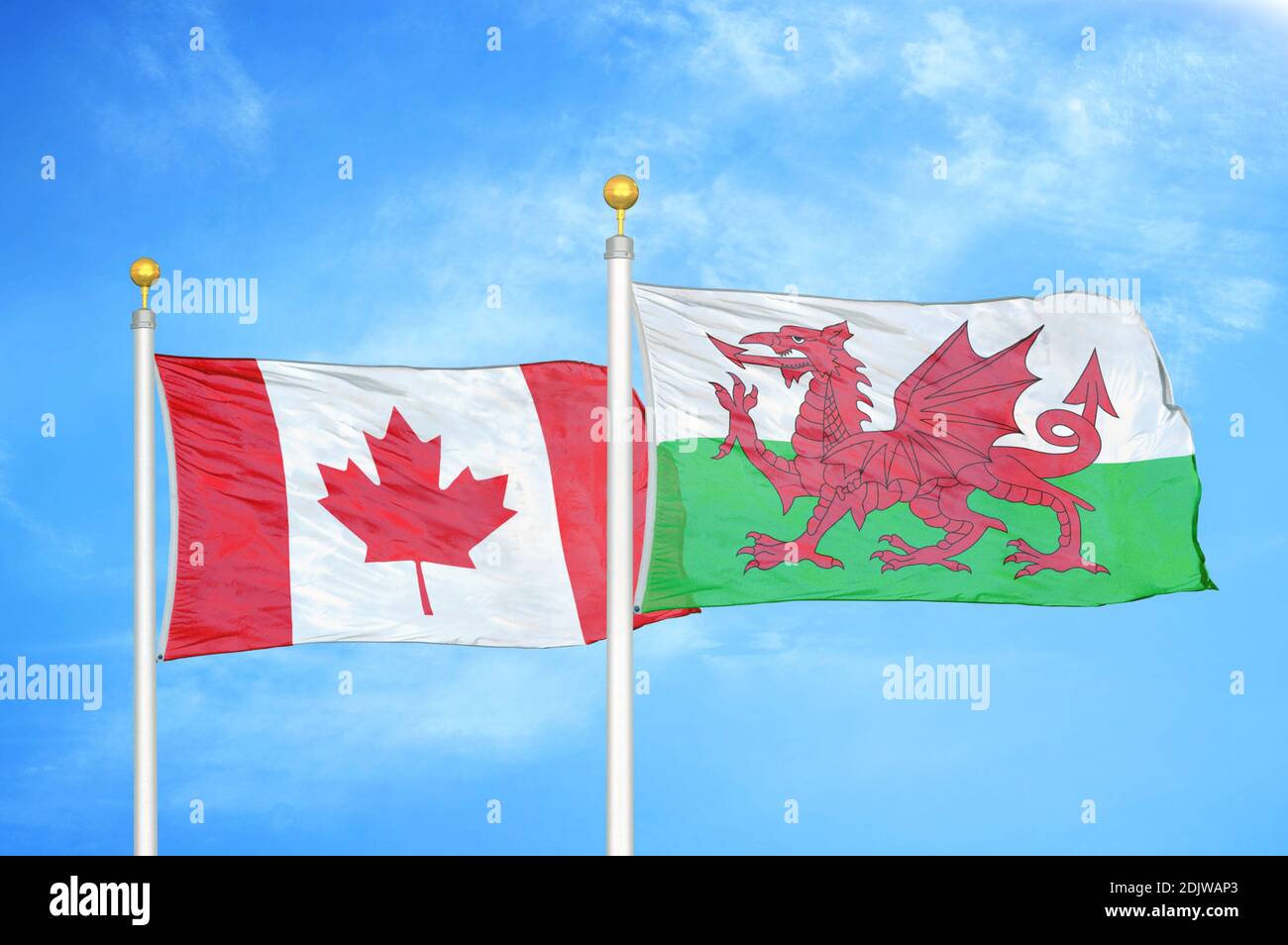 Kanada und Wales zwei Flaggen auf Fahnenmasten und blau bewölkt Himmel Stockfoto
