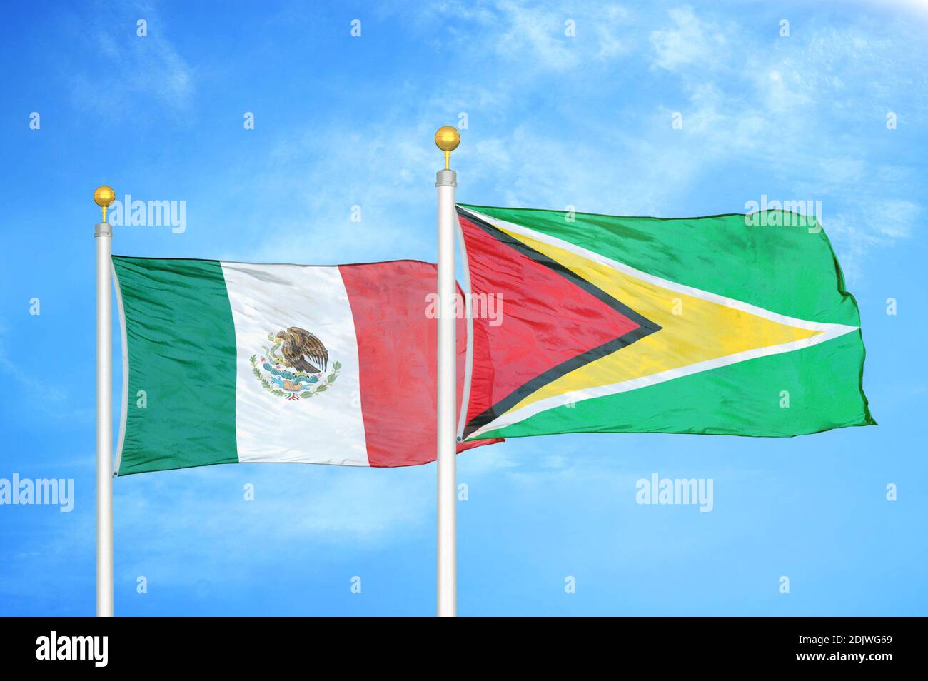 Mexiko und Guyana zwei Flaggen auf Fahnenmasten und blau bewölkt Himmel Stockfoto