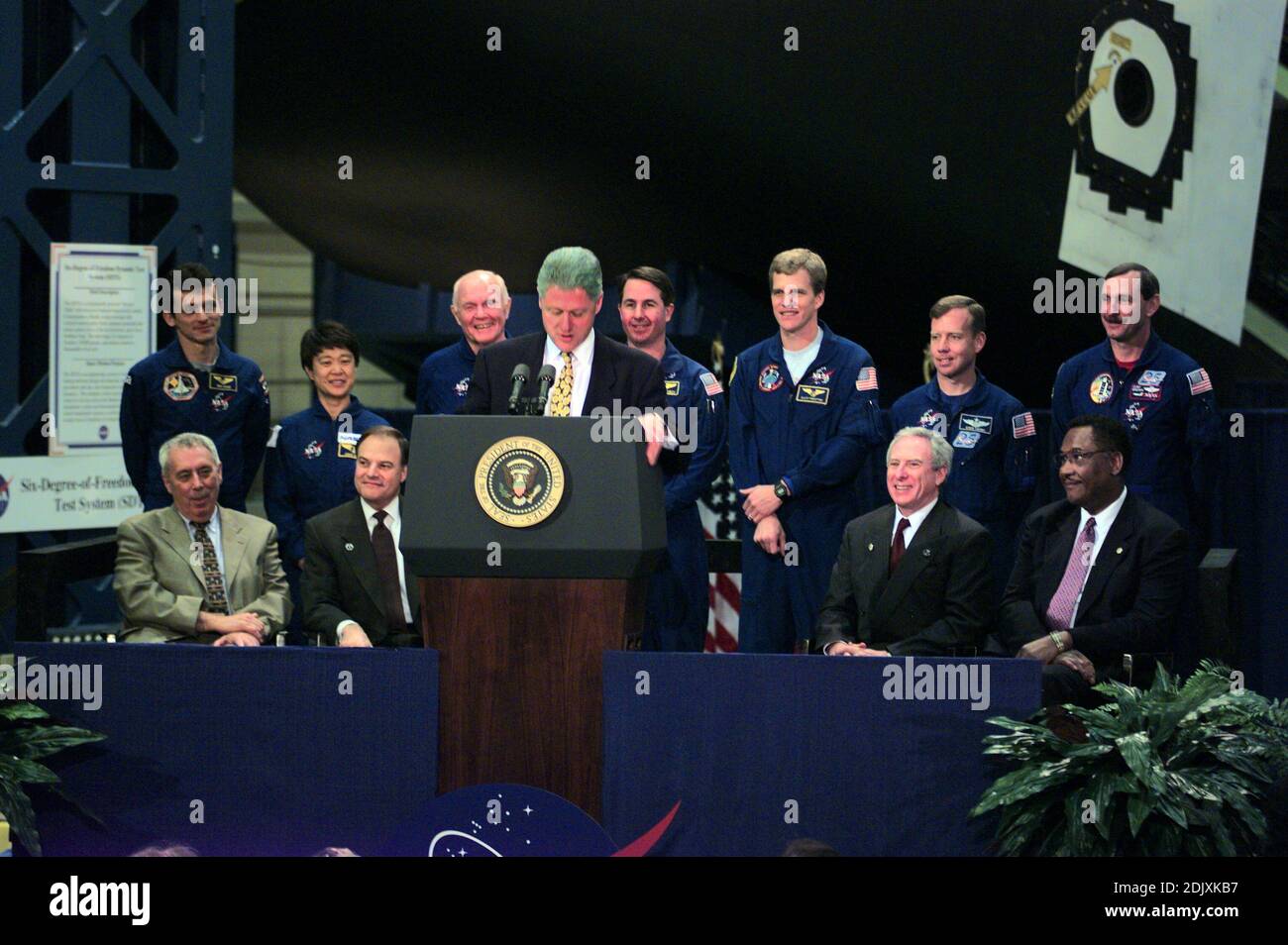 US-Präsident Bill Clinton (am Rednerpult) Adressen Mitarbeiter bei der NASA Johnson Space Center (JSC) während einer 14. April 1998 Besuch der Houston-Anlage. Sitzt hinter ihm (v.l.) sind JSC Direktor George W.S. Abbey, US-amerikanischer Jurist und Nick Lampson (Demokrat von Texas), NASA-Administrator Daniel Goldin und Houston Bürgermeister Lee Brown. Stehen Mitglieder der Besatzung von STS-95: (v.l.) Pedro Duque, Chiaki Mukai, US-Senator John H. Glenn Jr. (Demokrat of Ohio), Stephen K. Robinson, Scott E. Parazynski, Steven W. Lindsey und Curtis L. Brown Jr. Brown ist Kommandant der Schedu Stockfoto