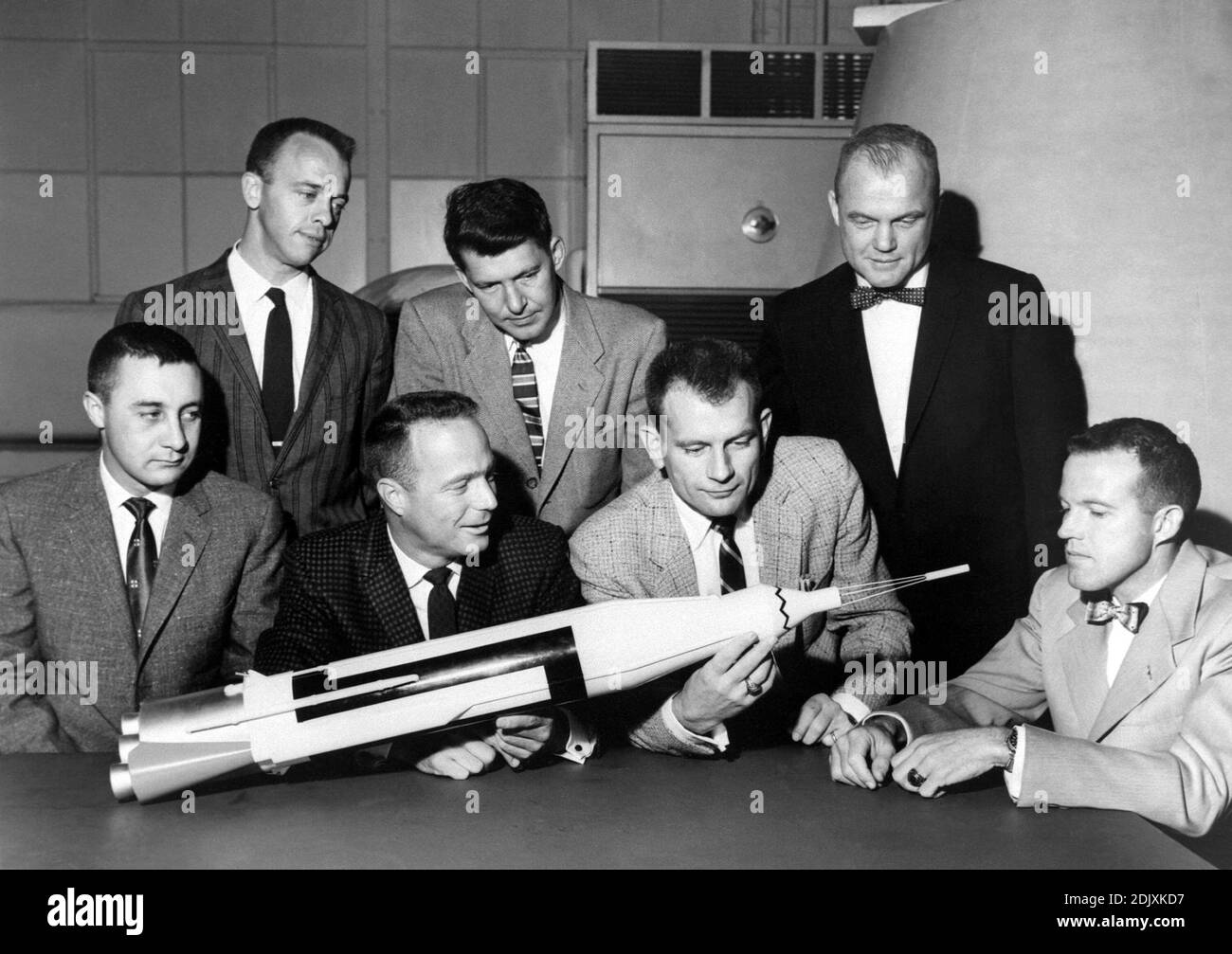 Die ursprünglichen 7 Mercury-Astronauten sind um einen Tisch bewundern eine Atlas-Modell am 30. April 1959 abgebildet. Stehend, links nach rechts sind Alan B. Shepard, Jr., Walter M. Schirra, Jr., und John H. Glenn, Jr.; sitzend, links nach rechts sind Virgil I. Grissom, M. Scott Carpenter, Donald Slayton und L. Gordon Cooper, Jr. Die 7 Mercury-Astronauten wurden in der amerikanischen Öffentlichkeit im April 1959 eingeführt. Die sieben Kriterien für die Auswahl waren wie folgt: 1. weniger als 40 Jahre alt; (2) weniger als 5 Fuß 11 Zoll hoch: 3. ausgezeichnete Kondition; 4. Bachelor-Abschluss in Maschinenbau oder gleichwertig; 5. Test-pilot Stockfoto