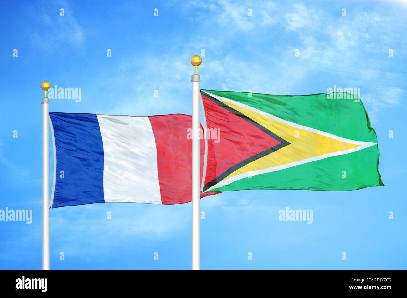 Frankreich und Guyana zwei Flaggen auf Fahnenmasten und blau bewölkt Himmel Stockfoto