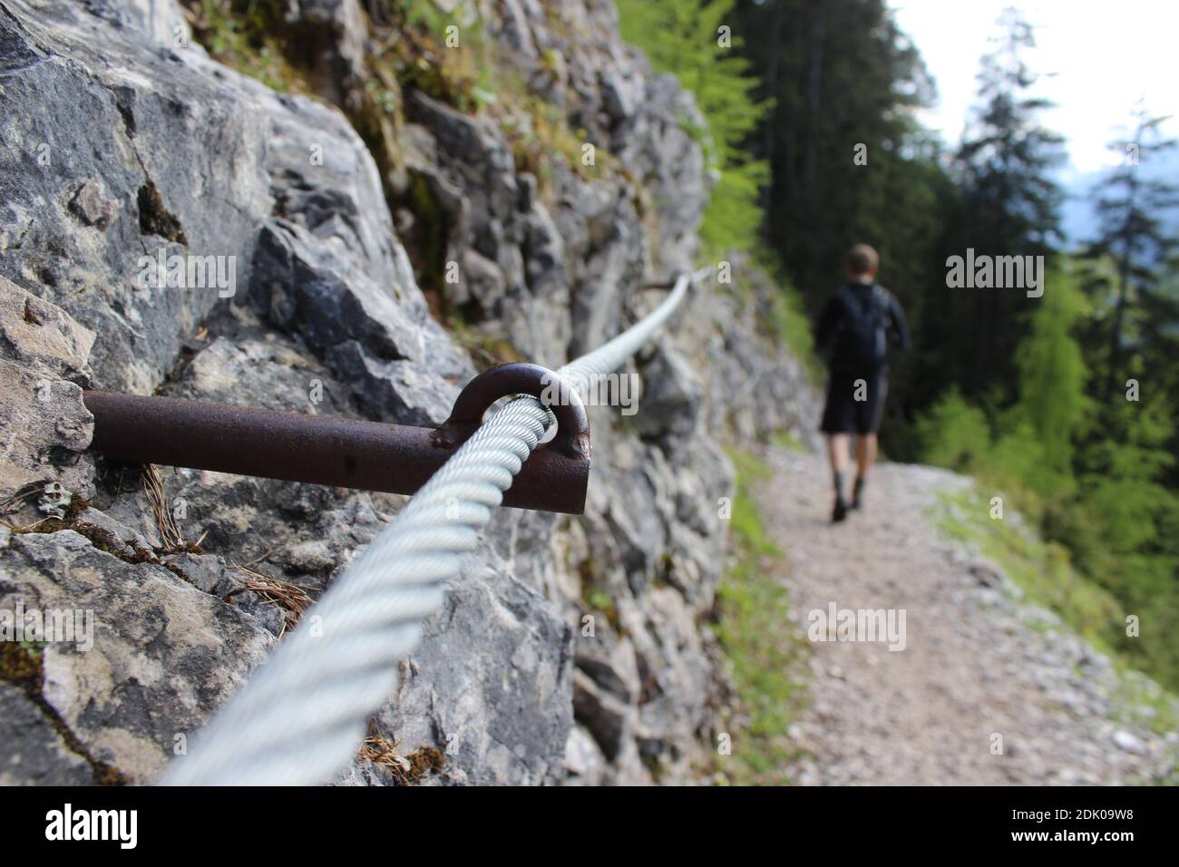 Stahlseil auf dem Weg zur Brunnsteinhütte mit einem Mann im Hintergrund Stockfoto