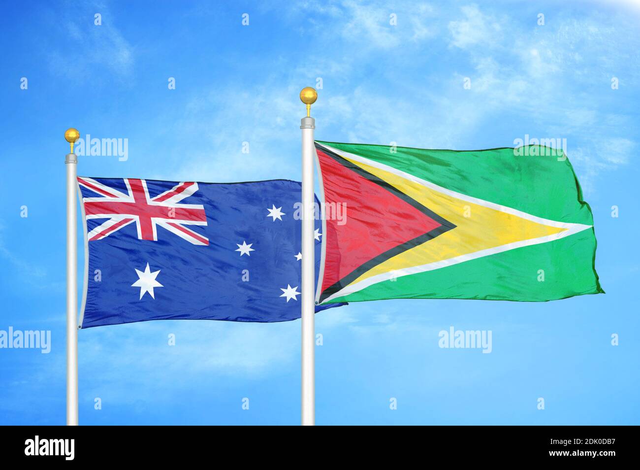 Australien und Guyana zwei Flaggen auf Fahnenmasten und blau bewölkt Himmel Stockfoto