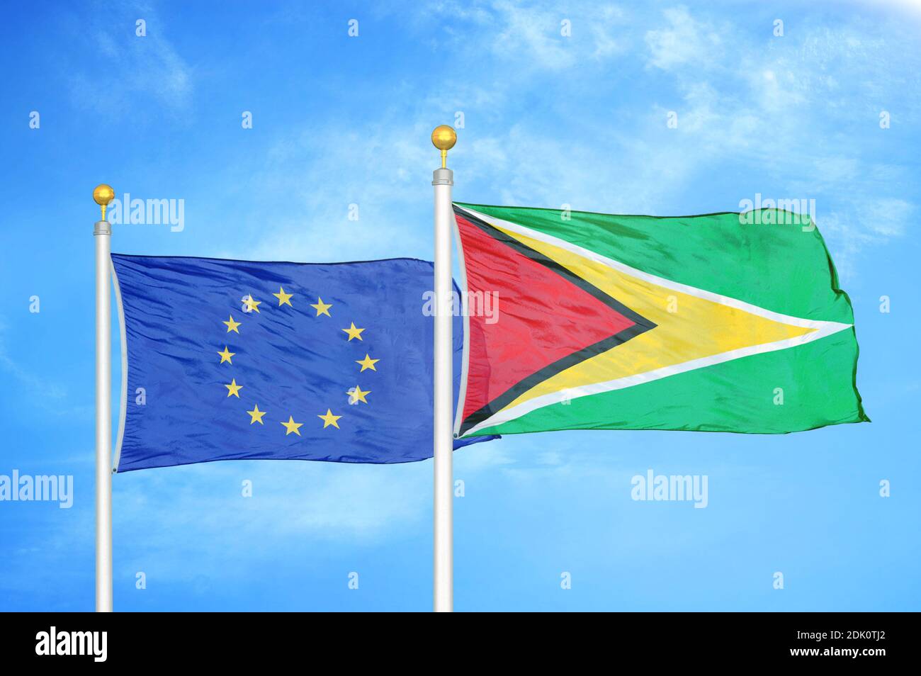 Europäische Union und Guyana zwei Flaggen auf Fahnenmasten und blau wolkiger Himmel Stockfoto