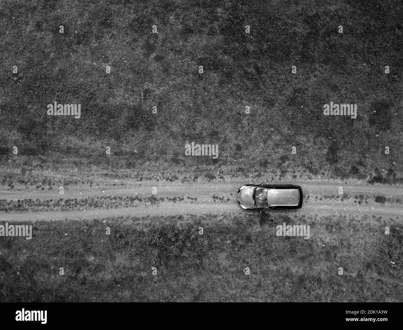 Eine Luftaufnahme eines Autos auf der Straße hinein Das Feld - Reisen mit dem Auto Stockfoto