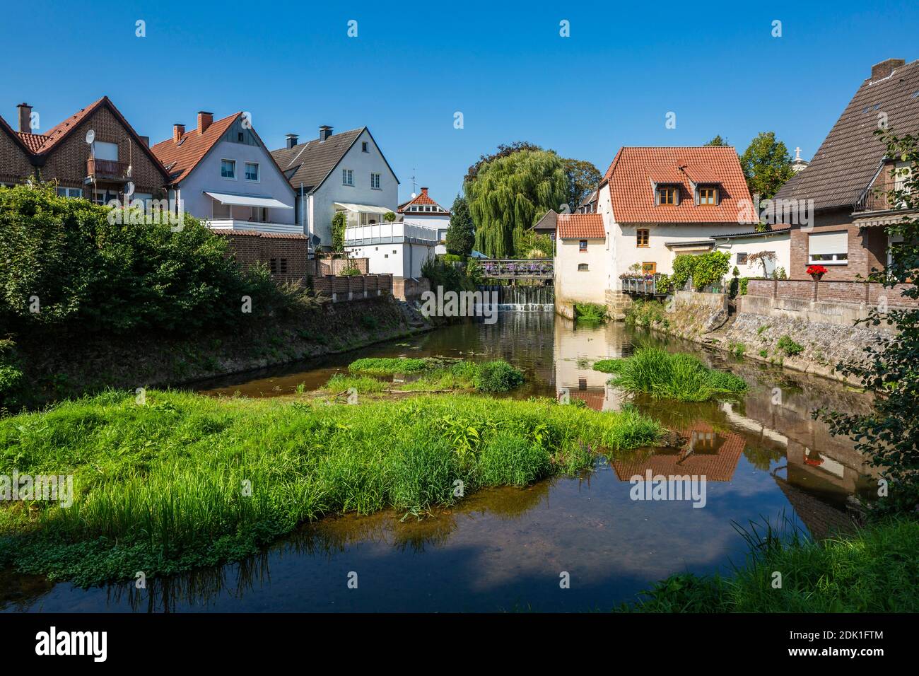 Deutschland, Borken, Borken-Gemen, Naturpark hohe Mark Westmünsterland, Münsterland, Westfalen, Nordrhein-Westfalen, Schlossmühle (rechts) und Bürgerhaeuser am Ufer der Bocholter AA in der Freiheit Gemen, Wassermühle Stockfoto