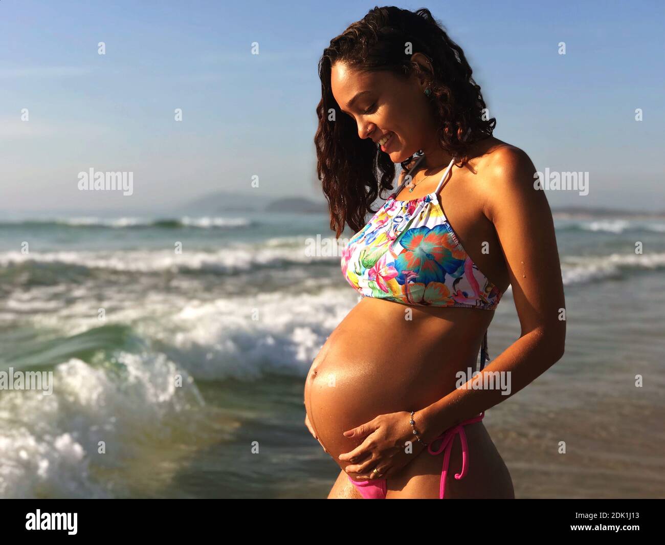 Schwangere, Die Bikini Trägt, Während Sie Am Strand Gegen Den Blauen Himmel  Steht Stockfotografie - Alamy