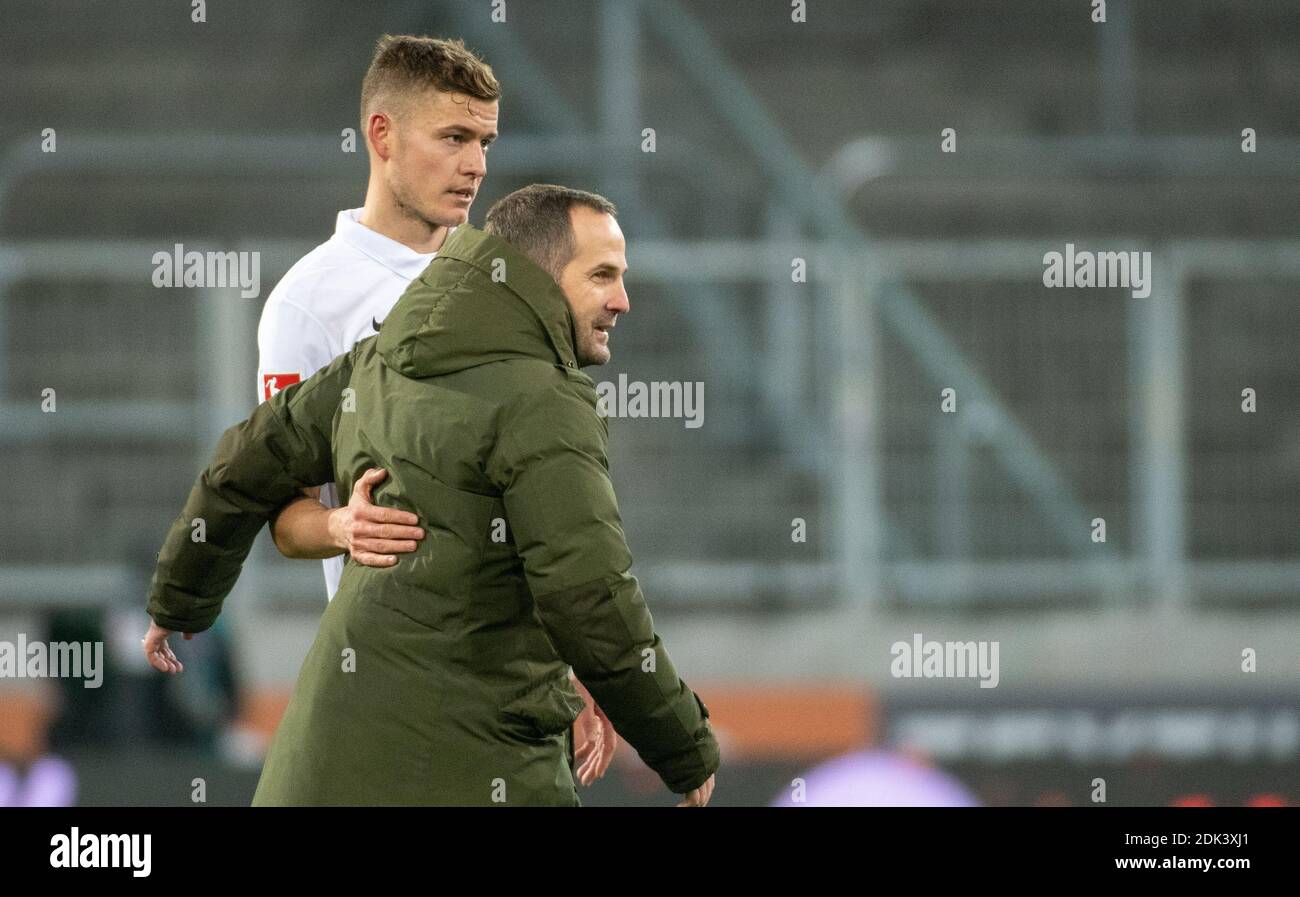 Augsburg, Deutschland. Dezember 2020. Fußball: Bundesliga, FC Augsburg - FC Schalke 04, 11. Spieltag in der WWK-Arena. Der Augsburger Alfred Finnbogaso (l) umarmt Trainer Manuel Baum (Schalke). Quelle: Stefan Puchner/dpa - WICHTIGER HINWEIS: Gemäß den Bestimmungen der DFL Deutsche Fußball Liga und des DFB Deutscher Fußball-Bund ist es untersagt, im Stadion und/oder aus dem Spiel aufgenommene Aufnahmen in Form von Sequenzbildern und/oder videoähnlichen Fotoserien zu nutzen oder auszunutzen./dpa/Alamy Live News Stockfoto