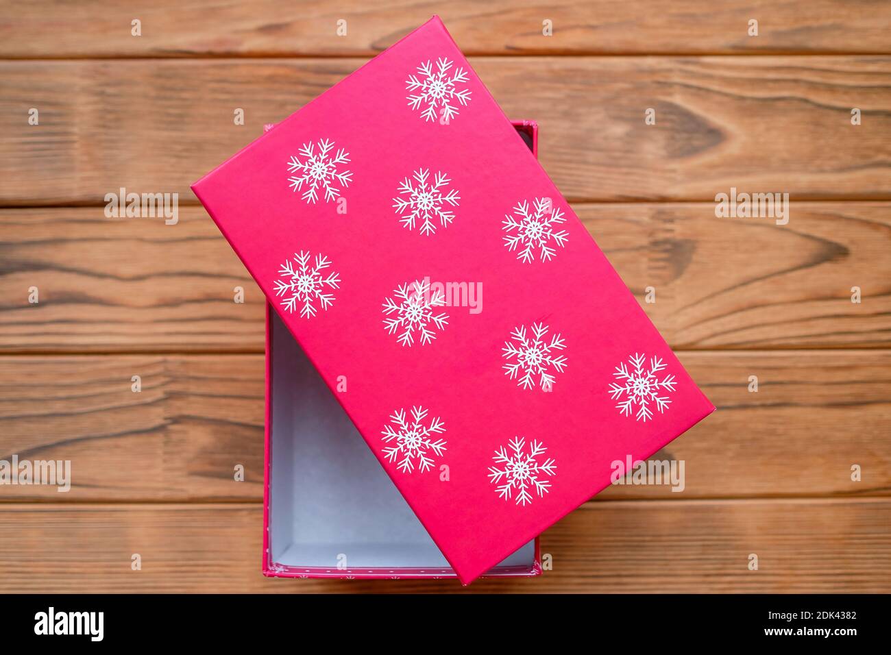 Rote Box mit weißen Schneeflocken. Geschenkverpackung. Stockfoto