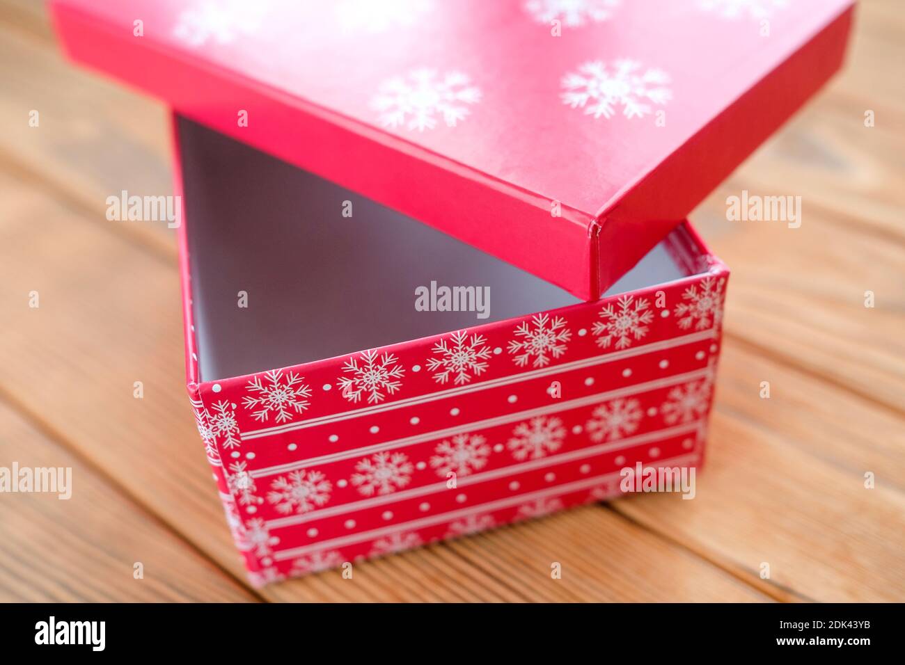 Rote Box mit weißen Schneeflocken. Geschenkverpackung für Neujahr. Stockfoto