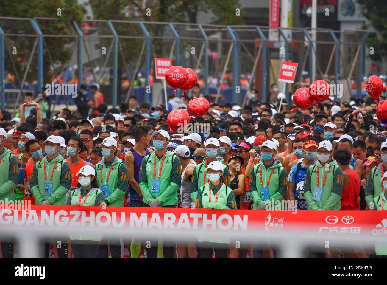 Freiwillige halten Ordnung auf dem Gelände des Marathons in Guangzhou, südchinesische Provinz Guangdong, 13. Dezember 2020. Die Veranstaltung findet von 7:30 bis statt Stockfoto