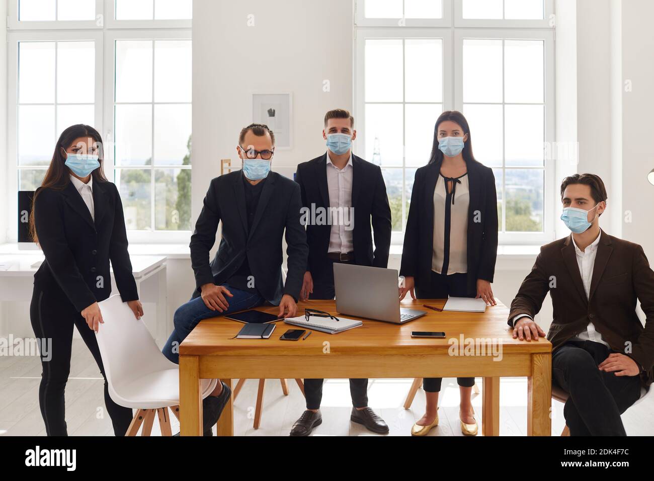 Gruppe von Geschäftskollegen Team in medizinischen Schutzmasken während Besprechung Stockfoto
