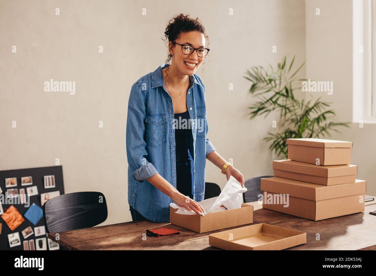 Frau Online-Geschäft Unternehmer Verpackung Paketkasten zu Hause Büro. Verkäuferin bereitet das Produkt für die Lieferung vor. Stockfoto