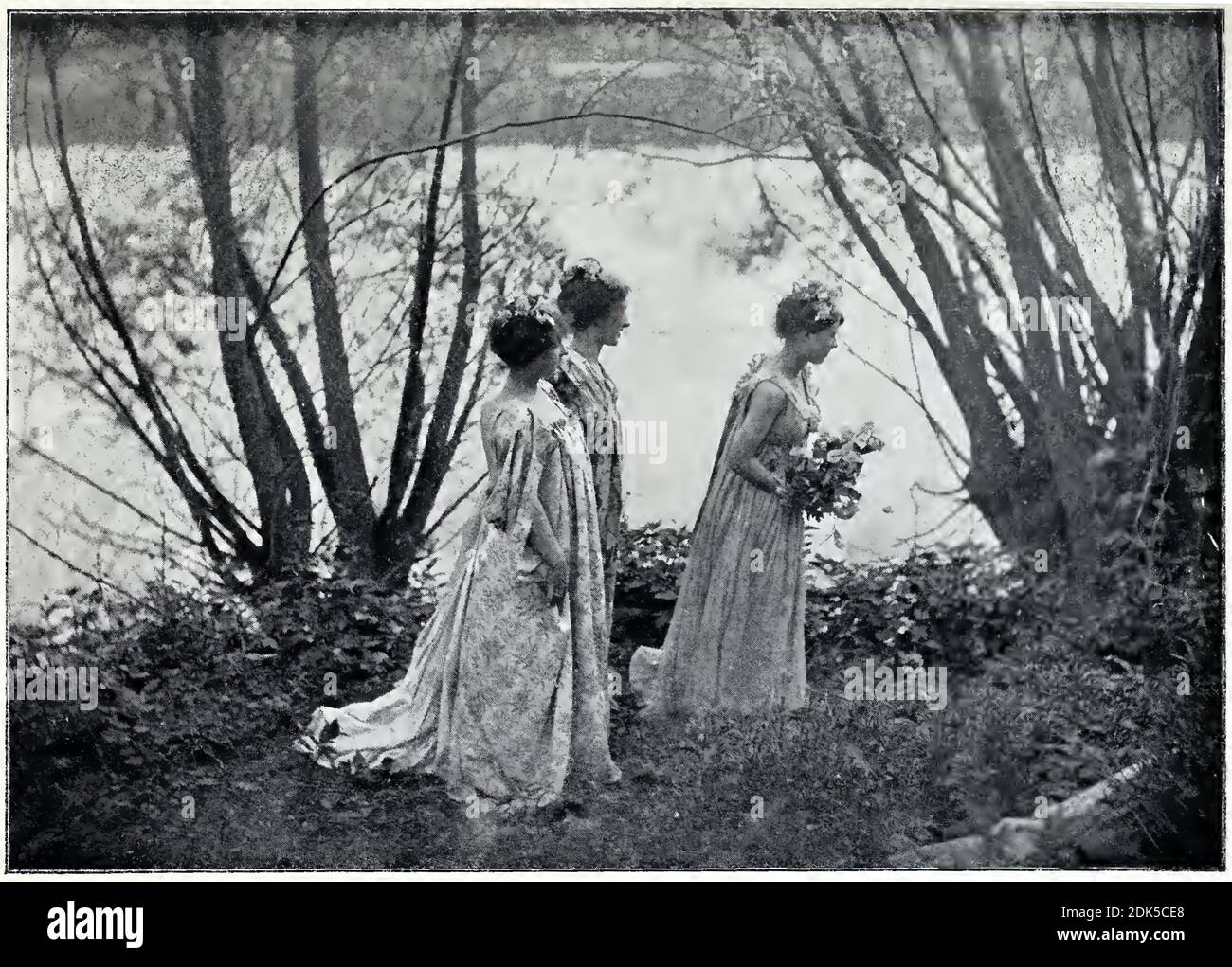 Vintage-Fotografie des französischen Fotografen Émile Joachim Constant Puyo. 3 Frauen mit Blumen im Haar in einem Stück namens Theorie. Stockfoto