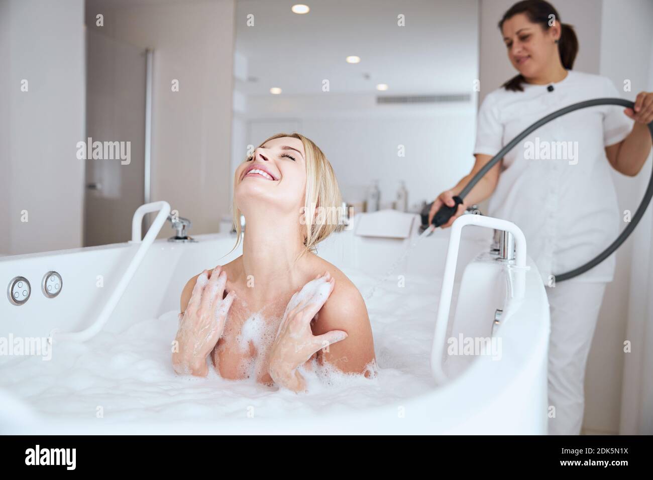 Schöne zufriedene Frau genießen eine Hydrotherapie Verfahren Stockfoto