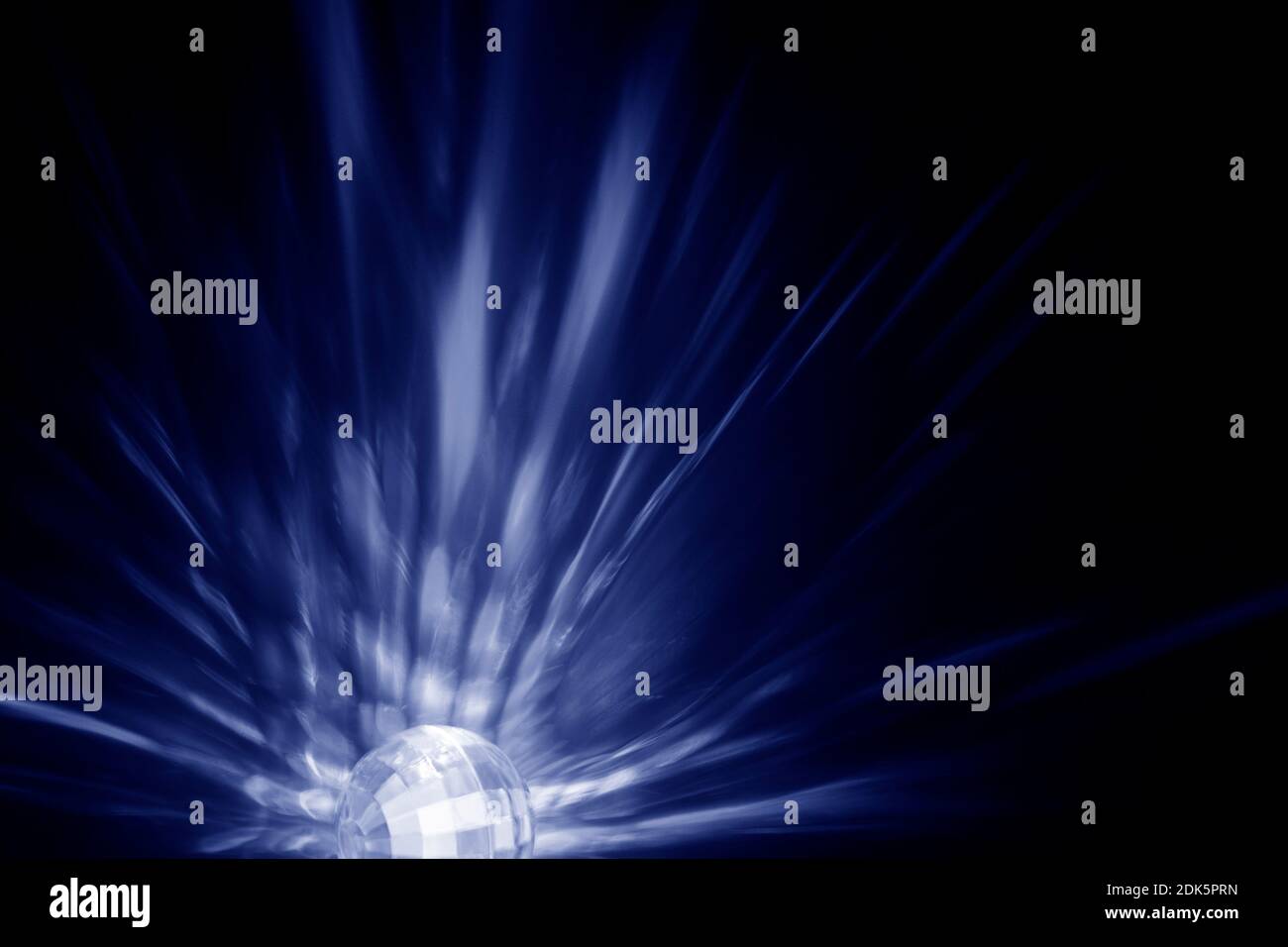 Lichtstrahlen oder Lichtstrahlen und eckige transparente Kugel bei Dunkelheit. Abstrakter, hochauflösender Hintergrund. Blauton. Stockfoto