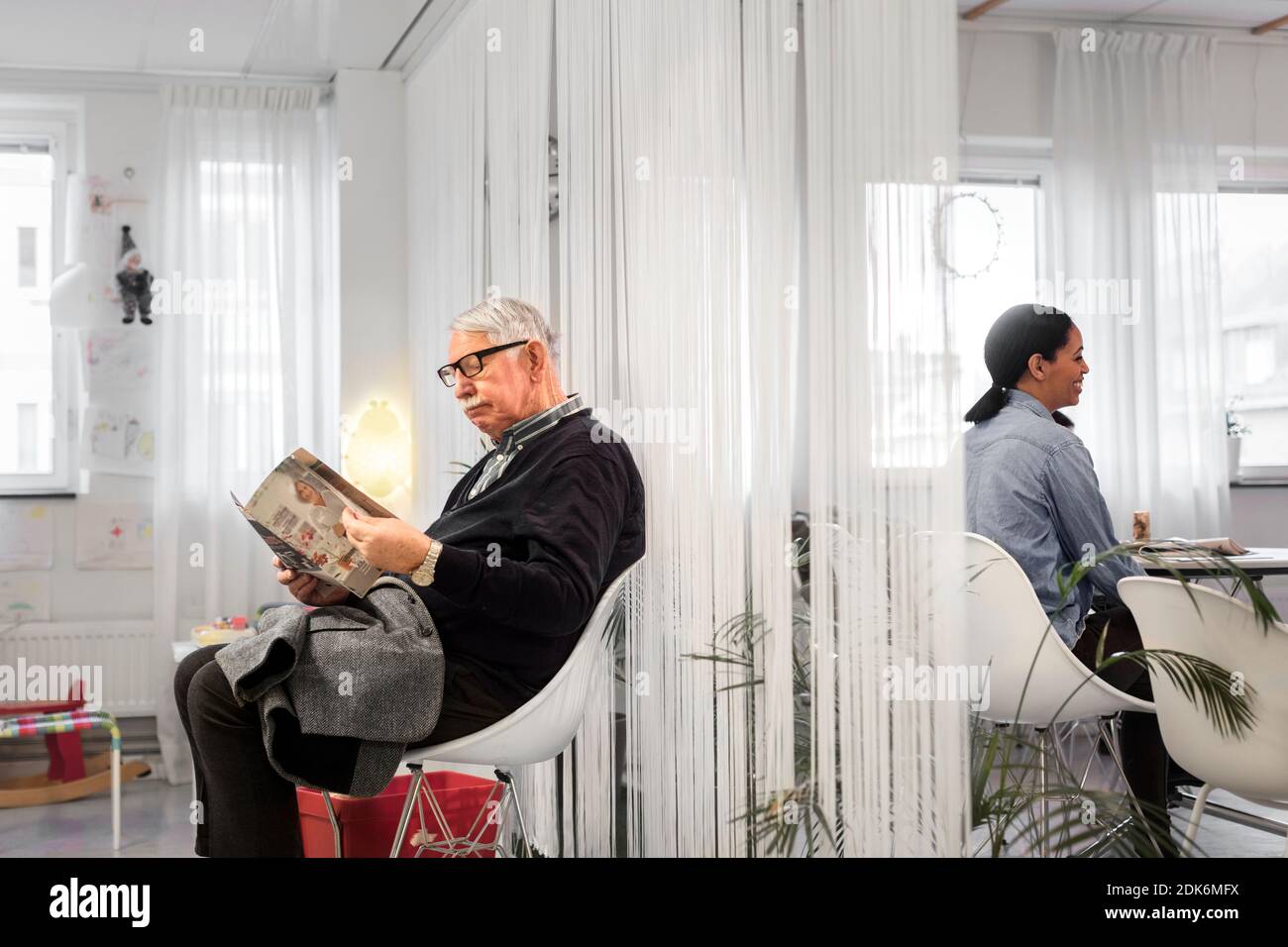 Mann liest Magazin im Warteraum Stockfoto