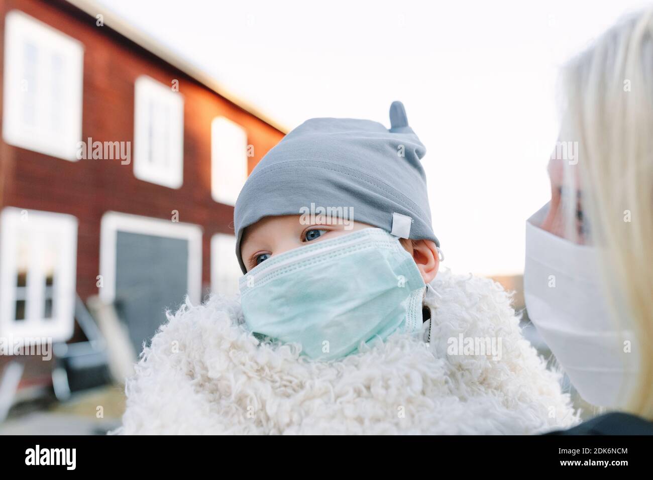 Kleines Kind trägt Hut und Gesichtsmaske Stockfoto