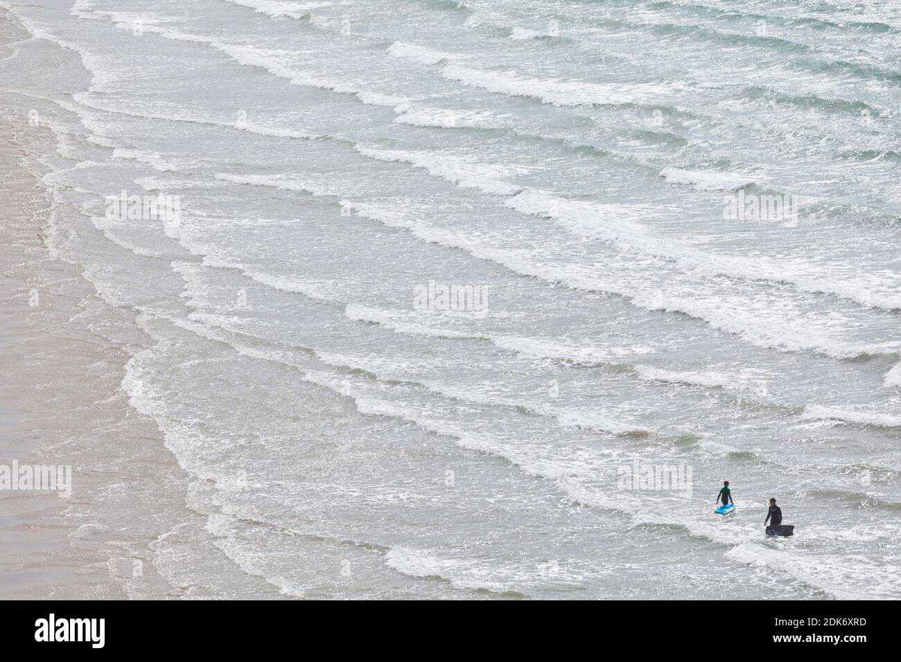 Am Strand von Erquy in der Bretagne nutzen Surfer die ankommenden Wellen. Stockfoto