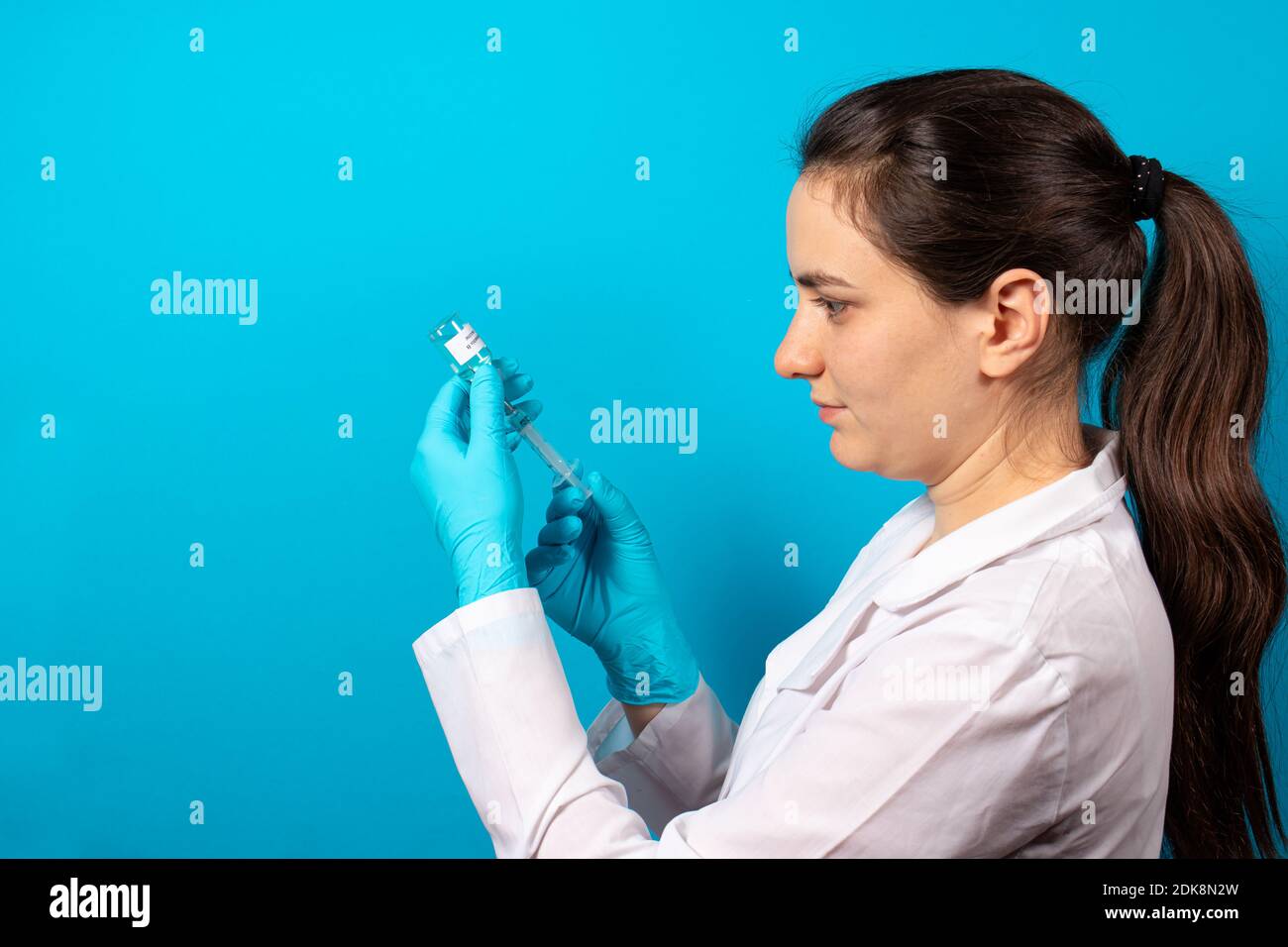 Ein Arzt oder Labortechniker hält ein Fläschchen mit einem Hepatitis-B-Impfstoff in der Hand. Mit einem Platz für Text auf blauem Hintergrund Stockfoto