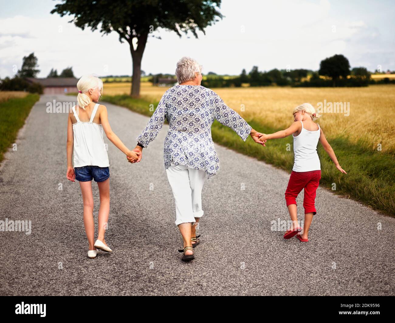 Oma Hand in Hand mit Enkeln auf dem Land Stockfoto
