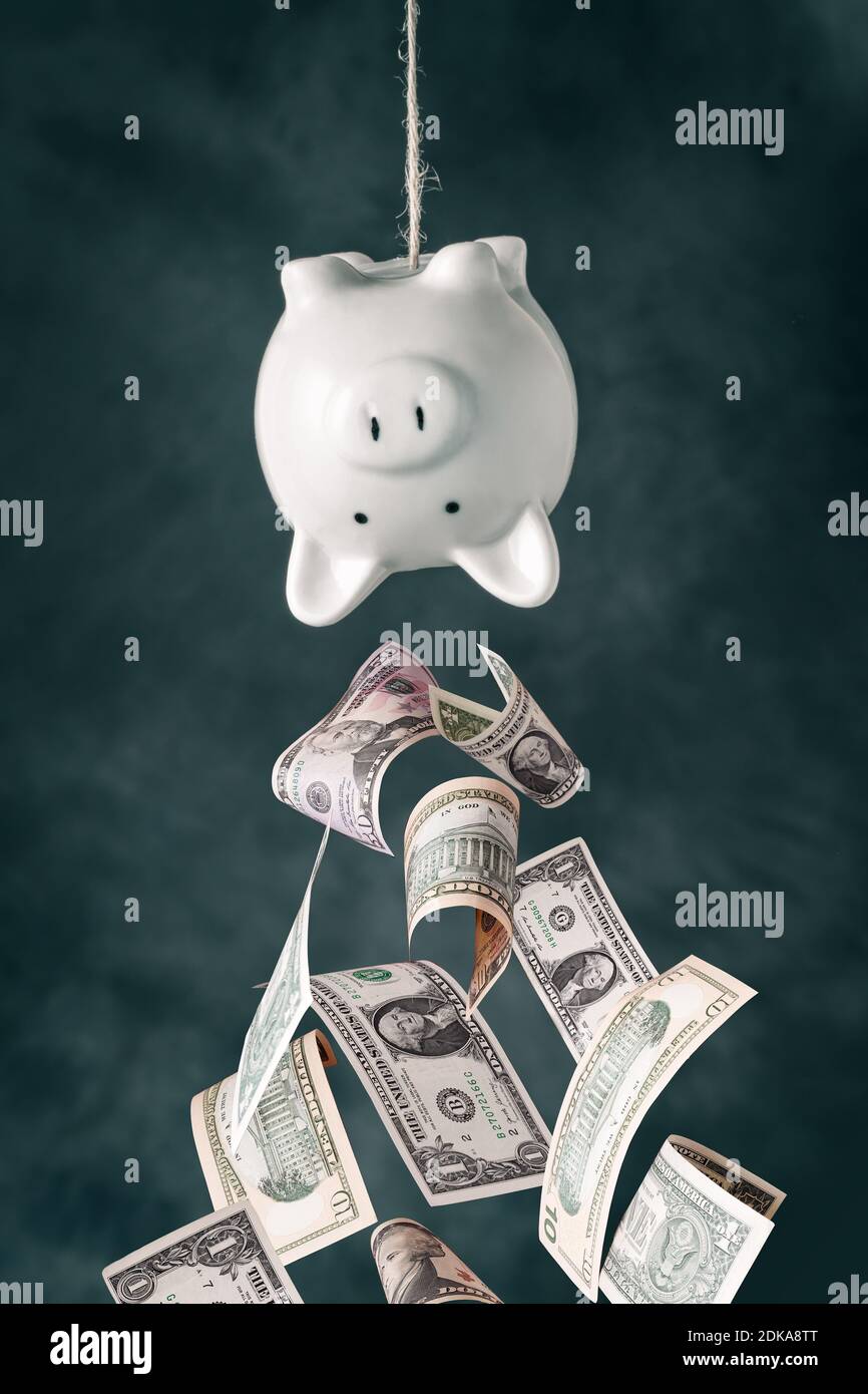 Dollar-Banknoten fallen aus dem Kopf nach unten Sparschwein Stockfoto