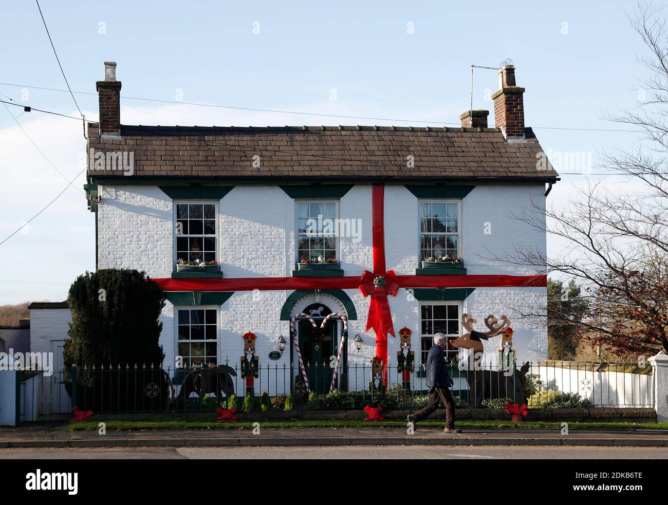 Scholar Green, Cheshire, Großbritannien. Dezember 2020. Ein Mann geht an einem Häuschen vorbei, das wie ein Weihnachtsgeschenk aussieht. Credit Darren Staples/Alamy Live News. Stockfoto