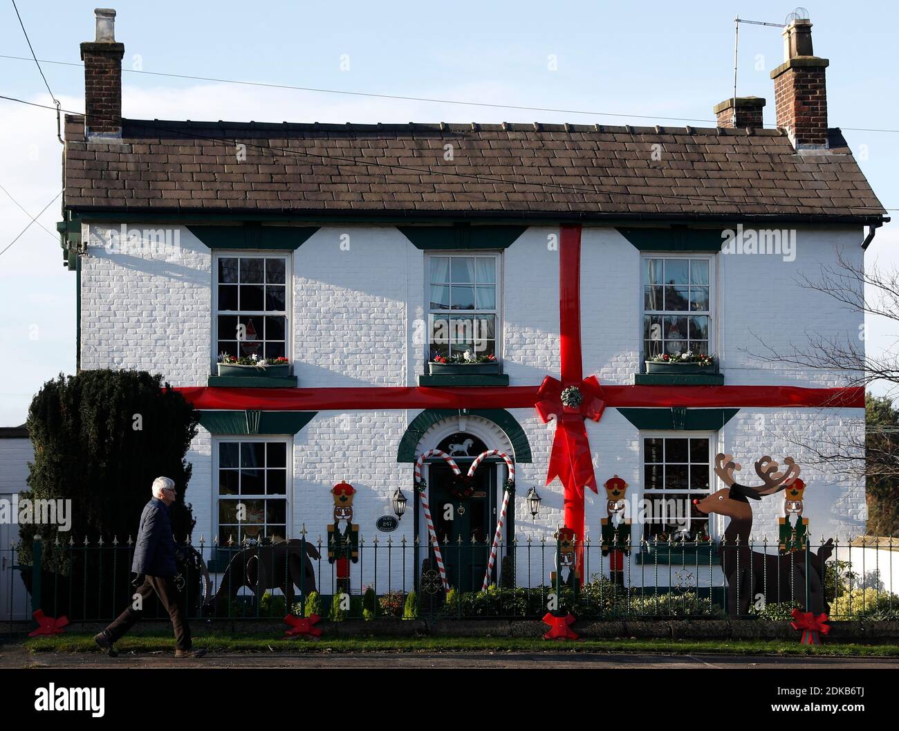 Scholar Green, Cheshire, Großbritannien. Dezember 2020. Ein Mann geht an einem Häuschen vorbei, das wie ein Weihnachtsgeschenk aussieht. Credit Darren Staples/Alamy Live News. Stockfoto