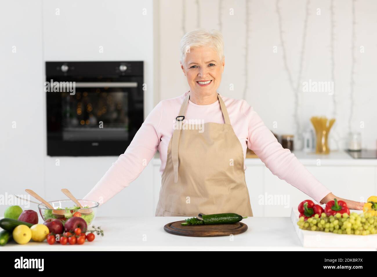 Happy Senior Lady Kochen In Der Küche Salat Zu Hause Machen Stockfoto