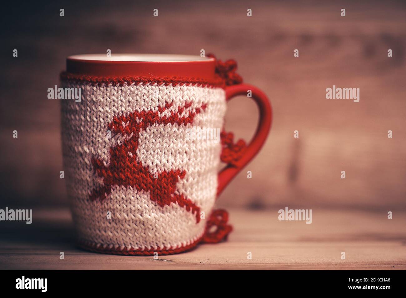 Christmas Cup mit gestrickten Ornamente auf Holz- Hintergrund. Stockfoto
