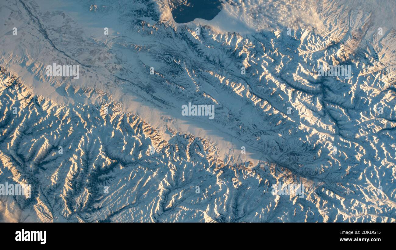KASACHSTAN / CHINA - Dezember 2020 - schneebedeckte Berge entlang der kasachischen-chinesischen Grenze, darunter der Sayram-See oben, sind vom Int Stockfoto