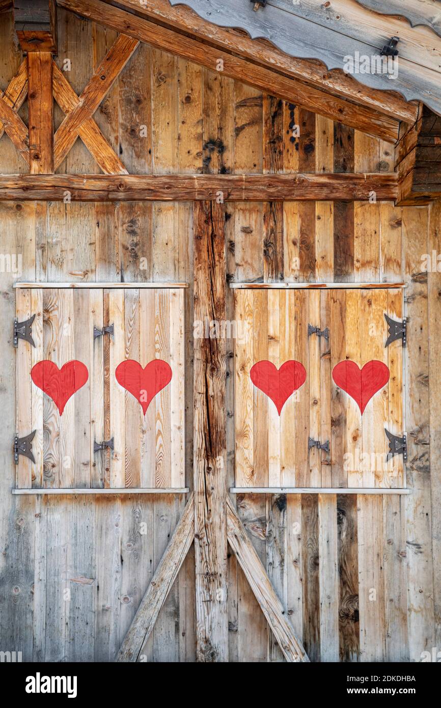 Holzgebäude im alpinen Stil mit Fensterläden mit roten Herzen, dolomiten, belluno, italien Stockfoto