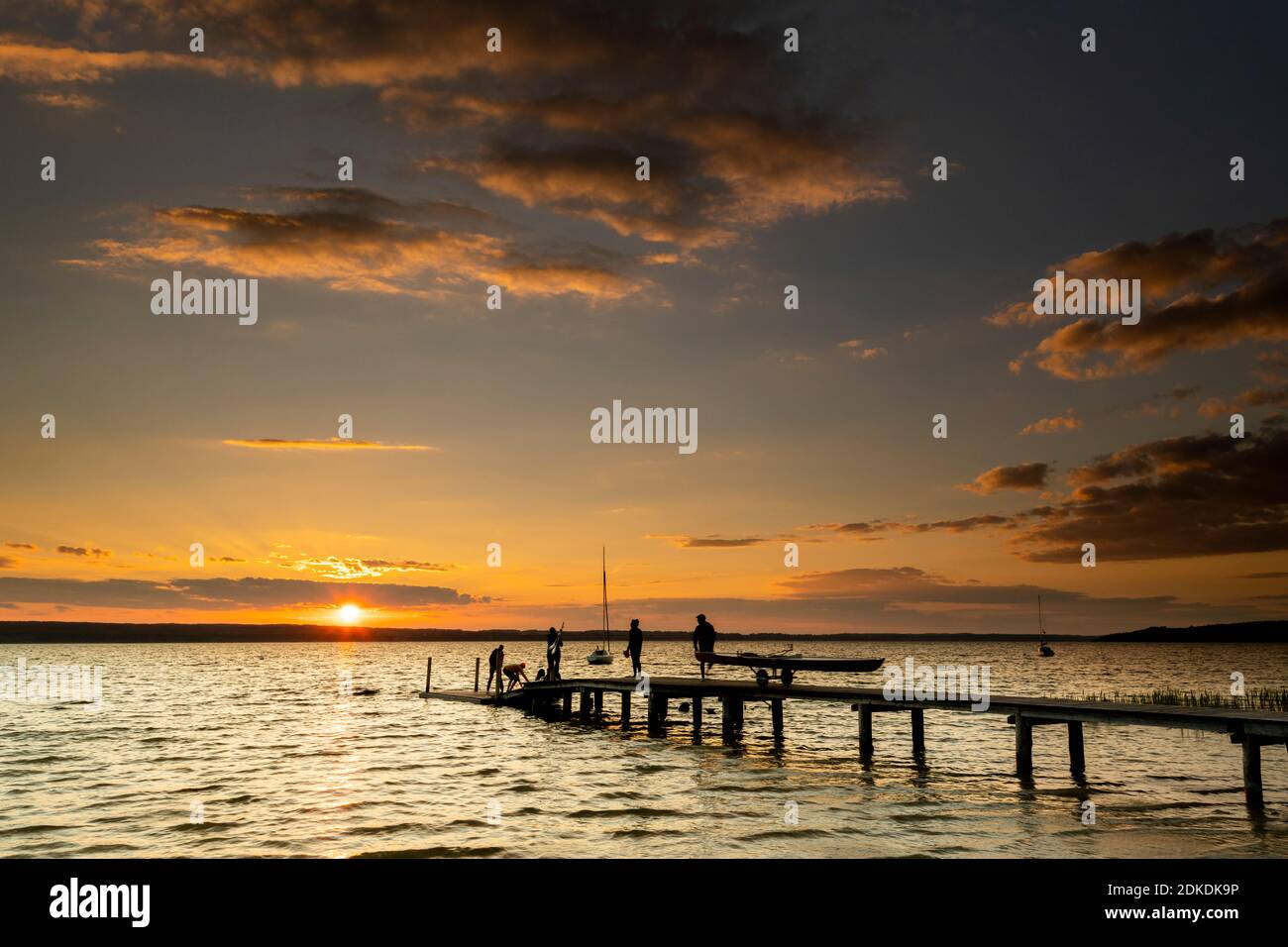 Hinterleuchtete Aufnahme bei Sonnenuntergang am Ammersee auf der TSV Fußgängerbrücke in Wartaweil. Stockfoto