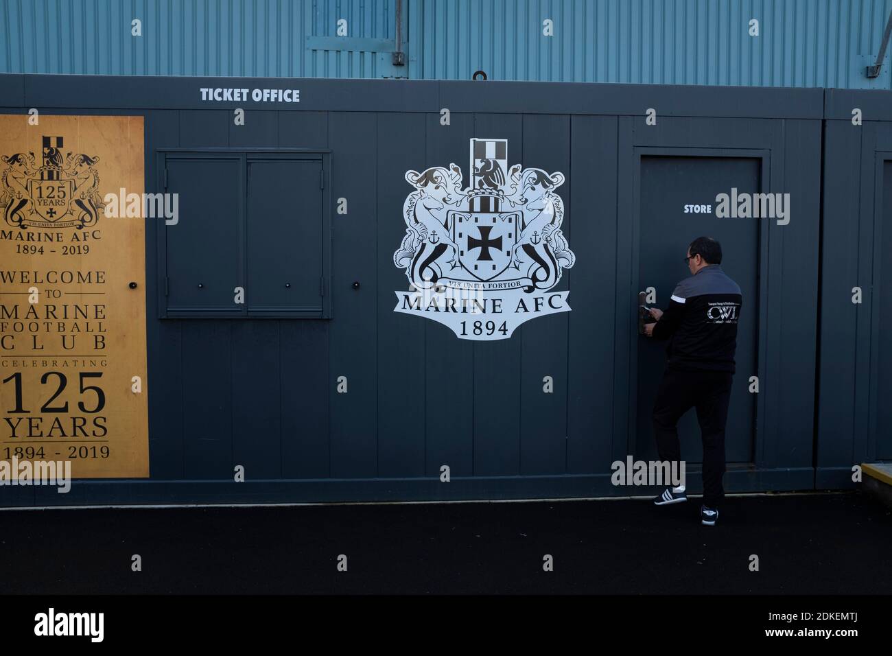 Ein Mitarbeiter des Bodenpersonals betritt den Lagerraum am Boden, bevor Marine Hyde United in einer ersten Runde der FA Trophy in der Marine Travel Arena, früher bekannt als Rossett Park, in Crosby spielt. Aufgrund der Coronavirus-Vorschriften, die Ligaspiele ausgesetzt hatten, waren die einzigen Spiele der Merseysider in Pokalwettbewerben, einschließlich ihres bevorstehenden Gleichspiels gegen Tottenham Hotspur in der dritten Runde des FA Cup. Marine gewann das Spiel mit 1:0, beobachtet mit einer zulässigen Kapazität von 400, mit den Besuchern, die zwei Männer in der zweiten Hälfte geschickt. Stockfoto