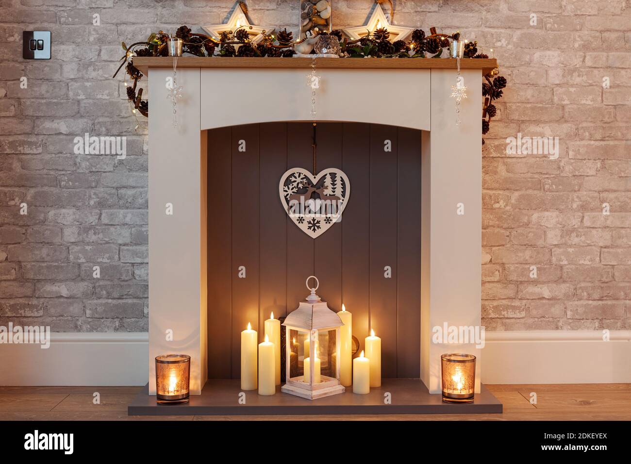 Heimelige Weihnachten Mantel Stück mit Kerzen und Kiefer Kegel Girlande Stockfoto