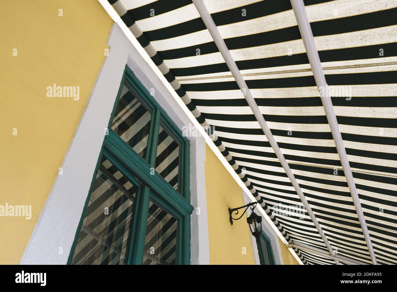 Architektonische geometrische Abstraktion mit Fenster und gestreifter Markise Stockfoto